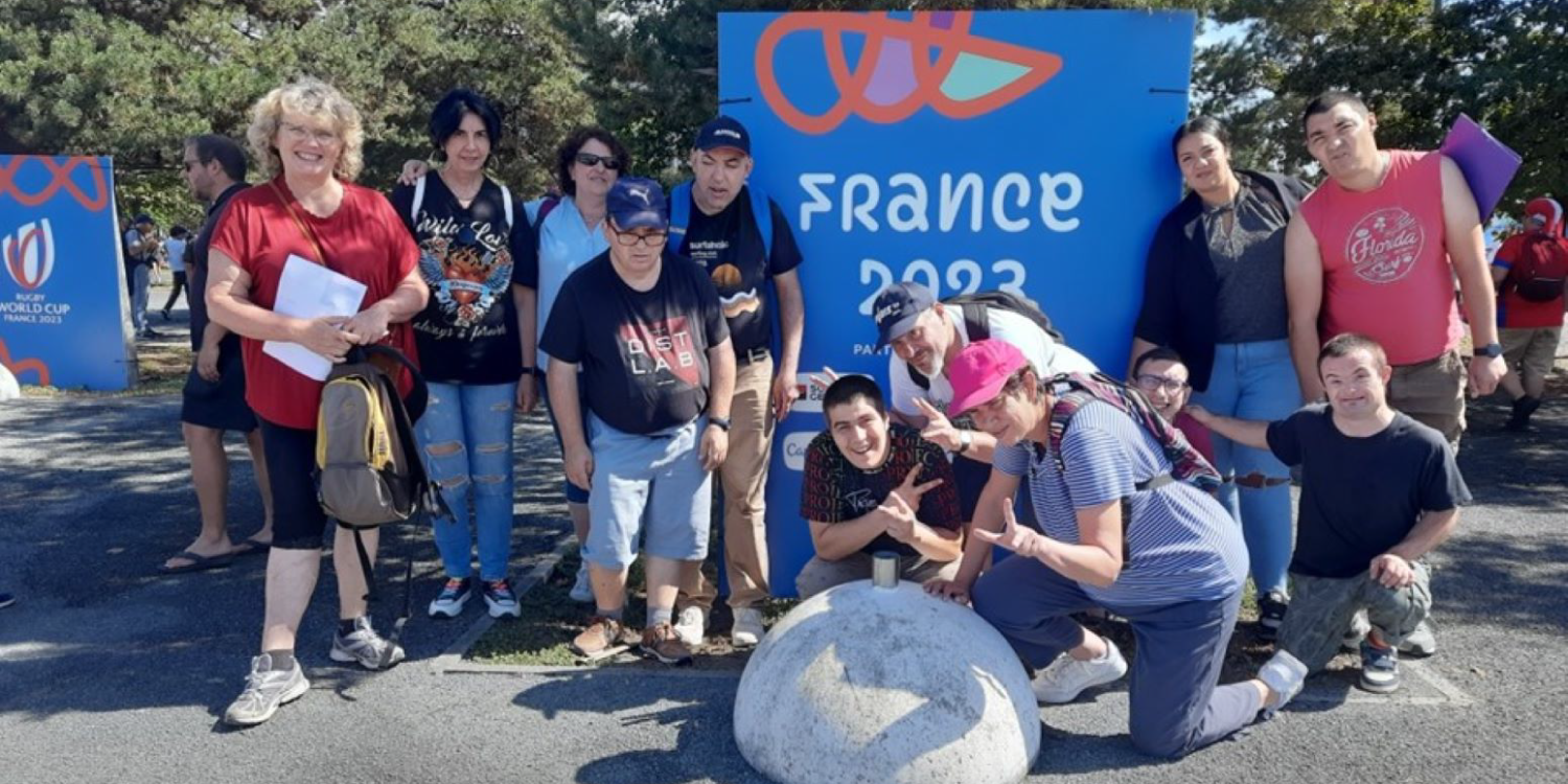 Photo de résidents du CDTPI devant un panneau "Coup du monde de Rugby 2023"